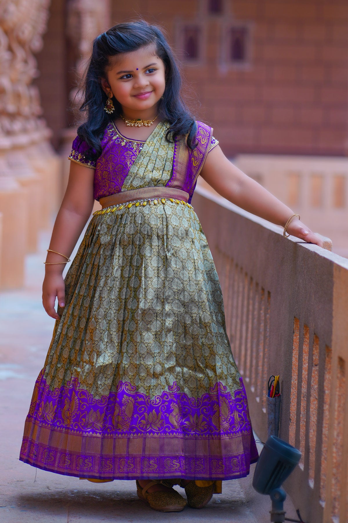 Baby Anika wearing purple pattu dress on balcony