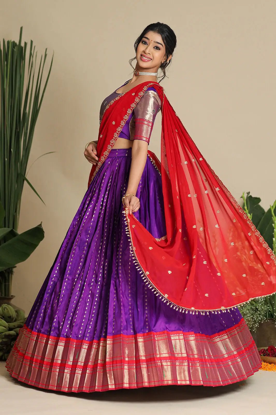 Flowing purple lehenga with red dupatta, twirling pose