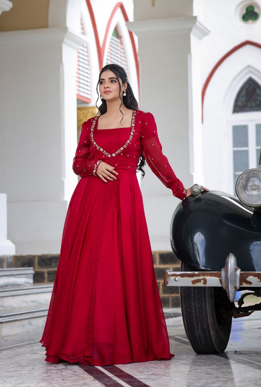 Model in Red Orchid IndoWestern dress beside vintage car