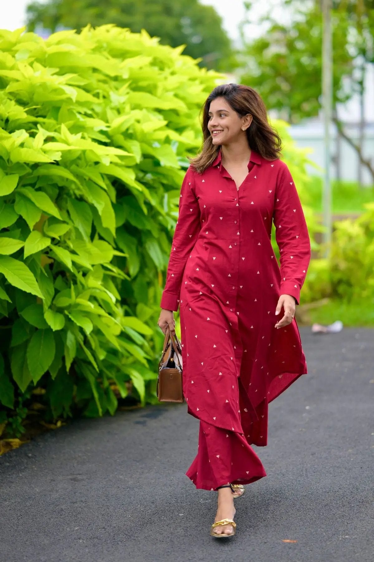 Woman in maroon handloom kurta set walking outdoors