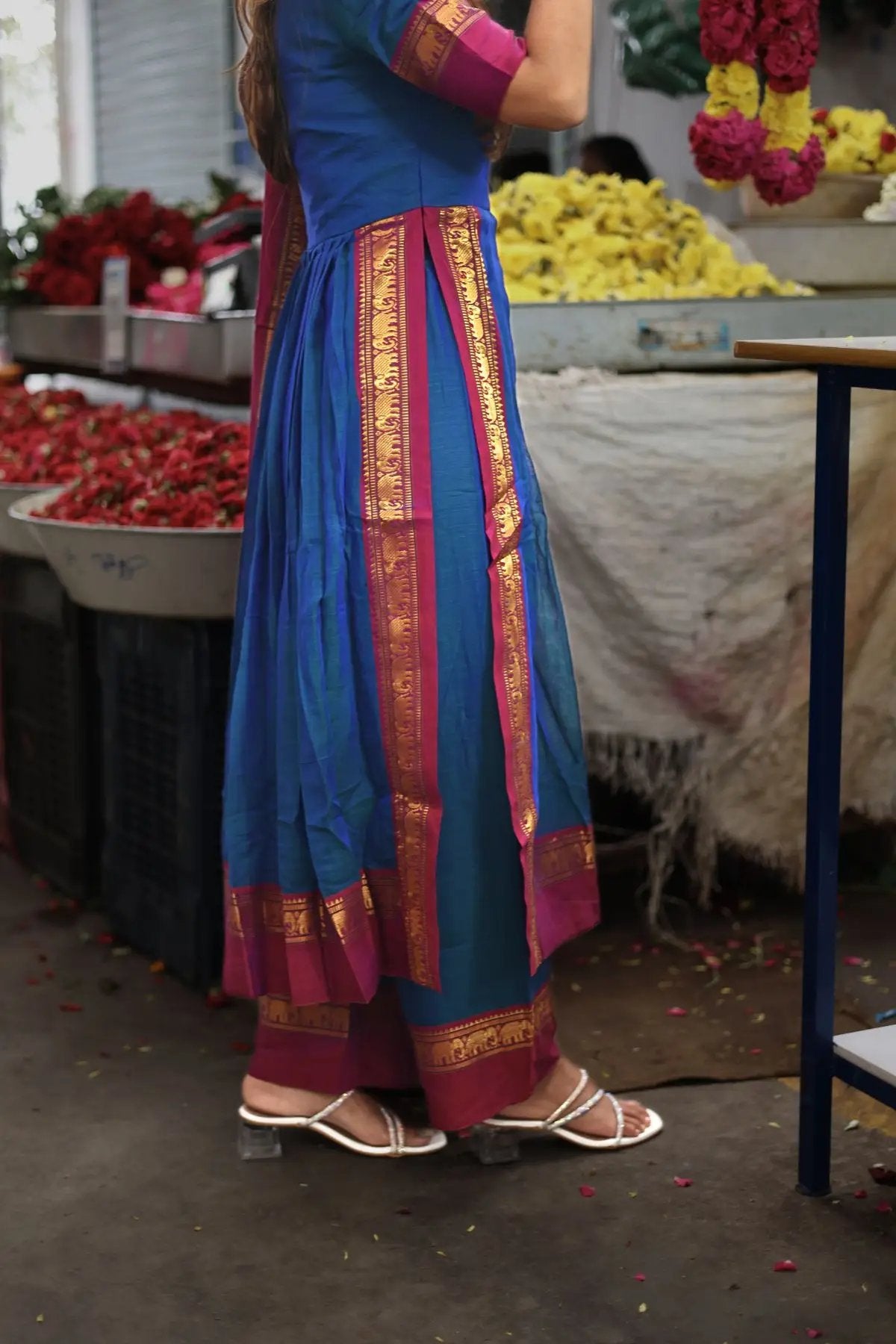 Side view of Saanchi Kurta Set in Peacock Blue, highlighting the pleated design and gold-bordered hem. A must-have traditional outfit from bullionknot.