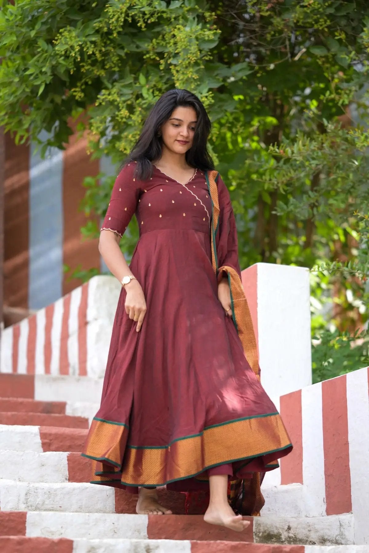 Maroon handloom dress with golden accents, outdoor setting