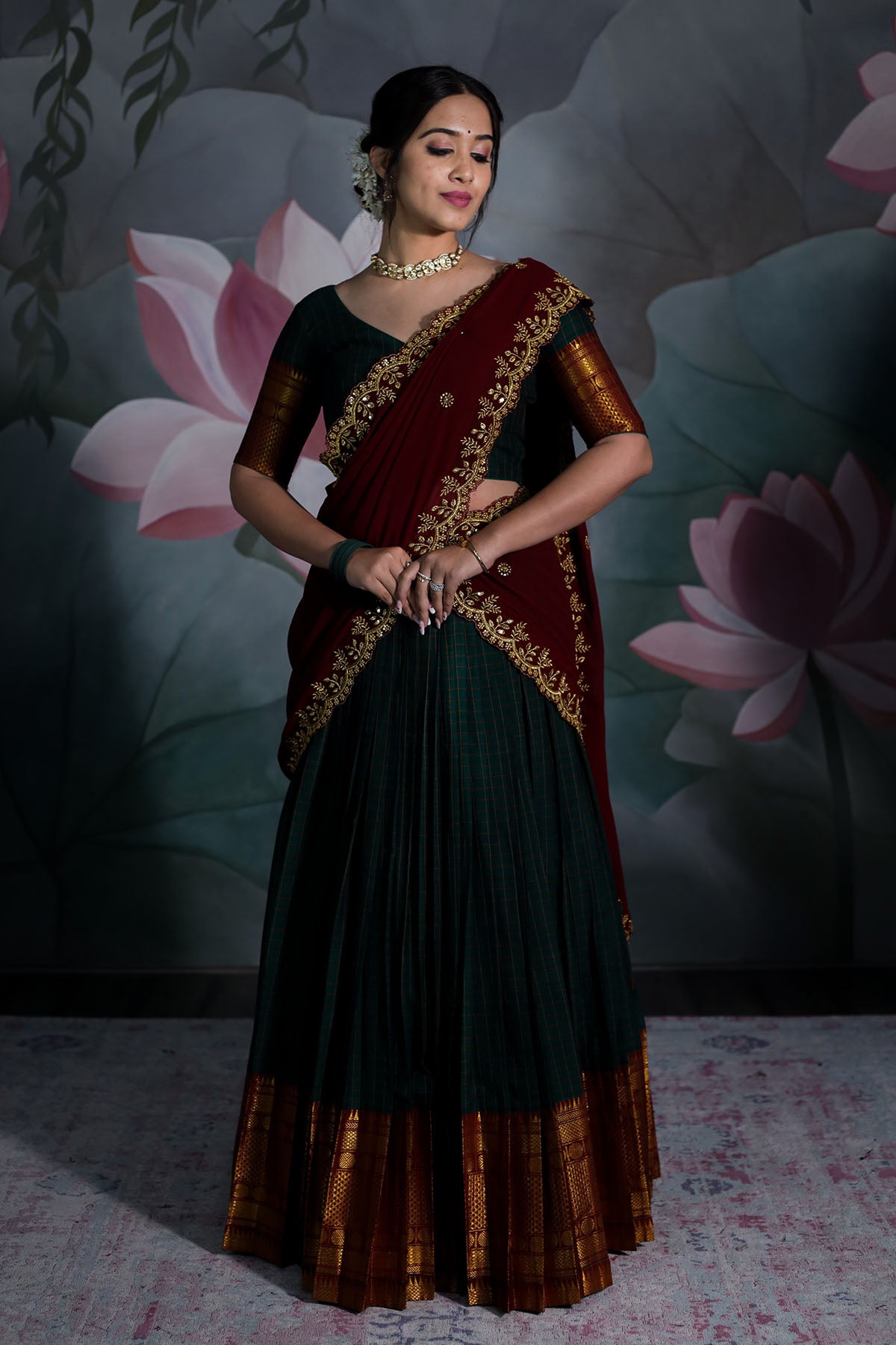 a woman in bottle green and maroon handloom half saree