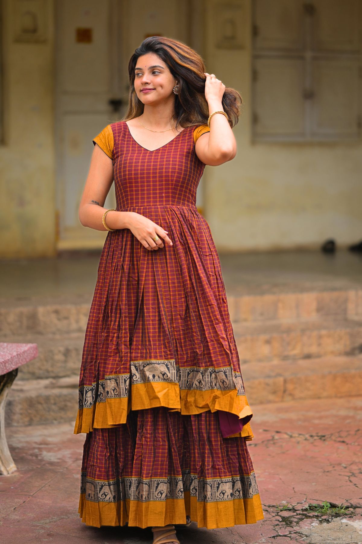 Gajadanta Indo Western Dress in maroon with a V-neckline and golden motifs. Handloom two-layer design blending tradition with modern elegance.