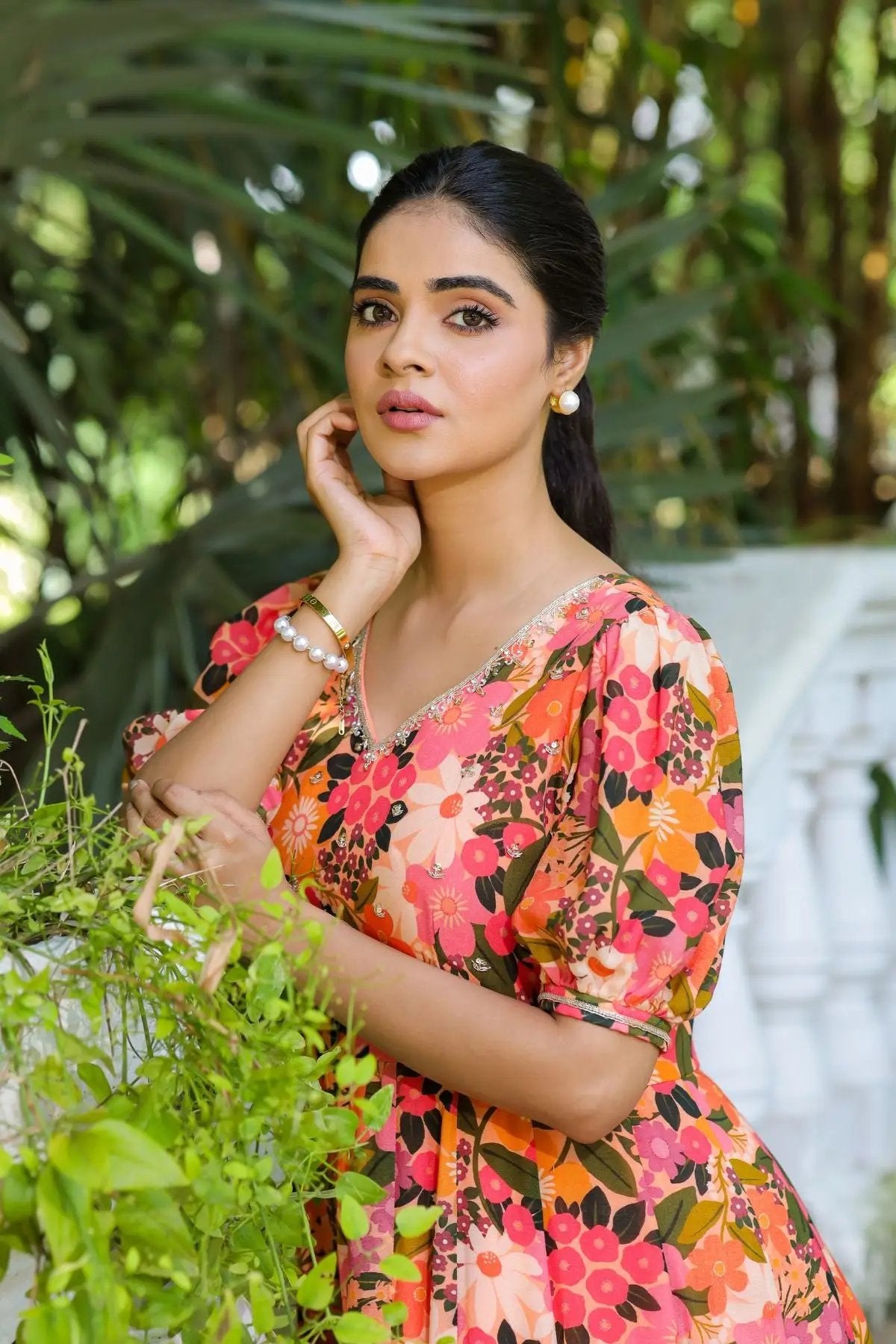 Elegant portrait of a model in the Gulmohar Maxi Dress in Peach, emphasizing the intricate neckline detailing and vibrant floral pattern.