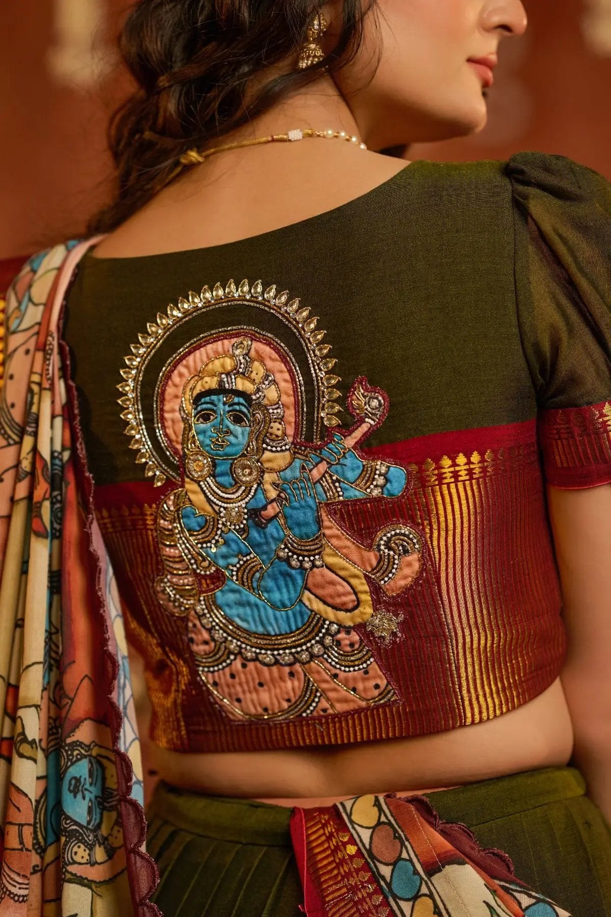 Close-up of Krishna patchwork on the back of the KrishnaLeela Lehenga Set blouse, featuring intricate embroidery and zari detailing.