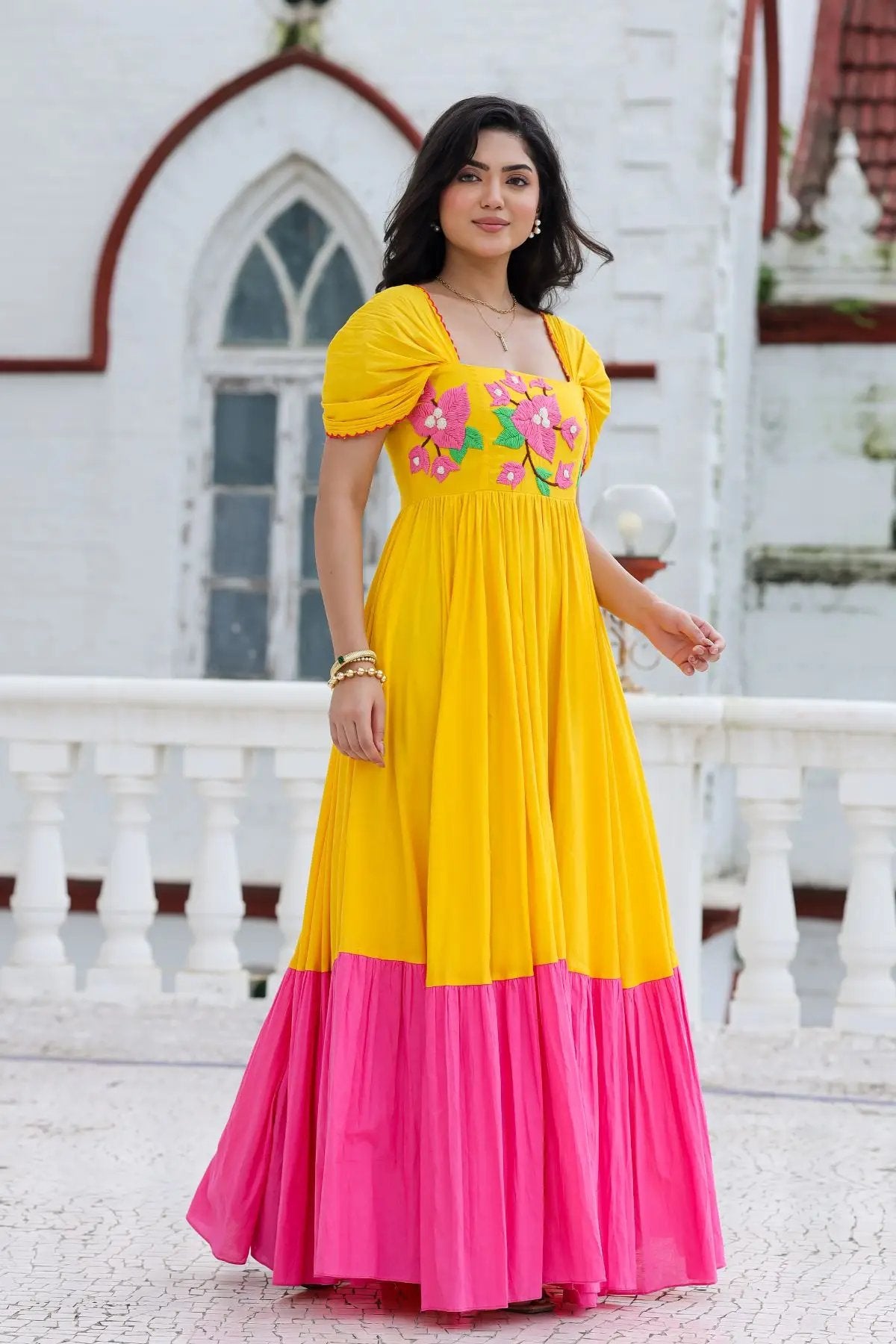 Model posing in yellow Daffodil Dream Maxi Dress with pink skirt