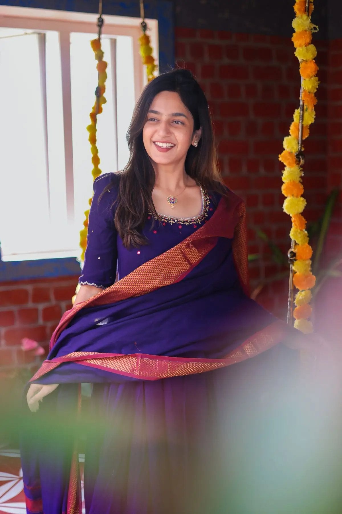 Woman wearing Meghna Anarkali dress in purple, smiling