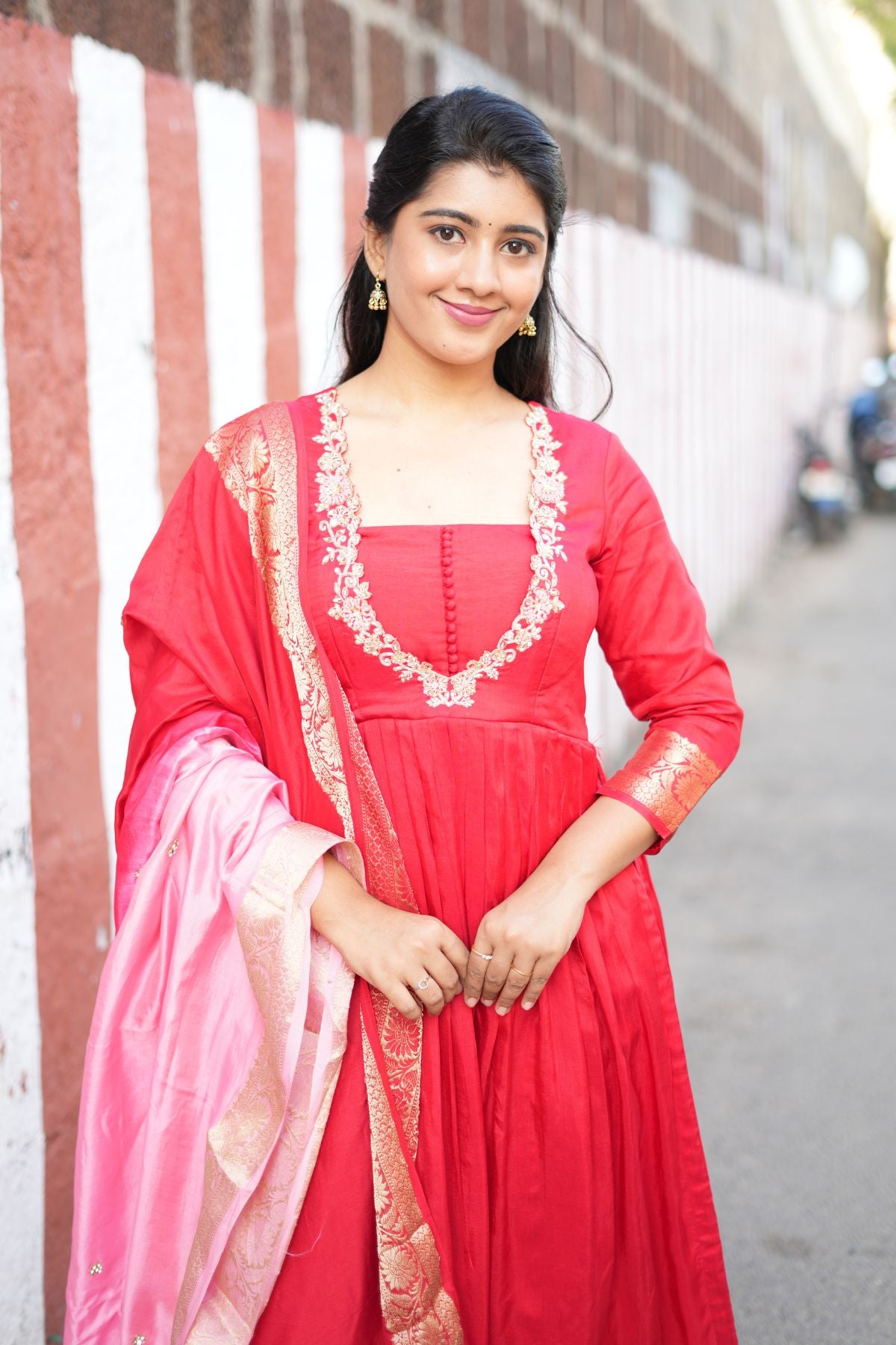 Model wearing Madhubala Silk Kurta Set in Red, styled with a pink Banarasi dupatta. A graceful ethnic dress ideal for weddings and celebrations.