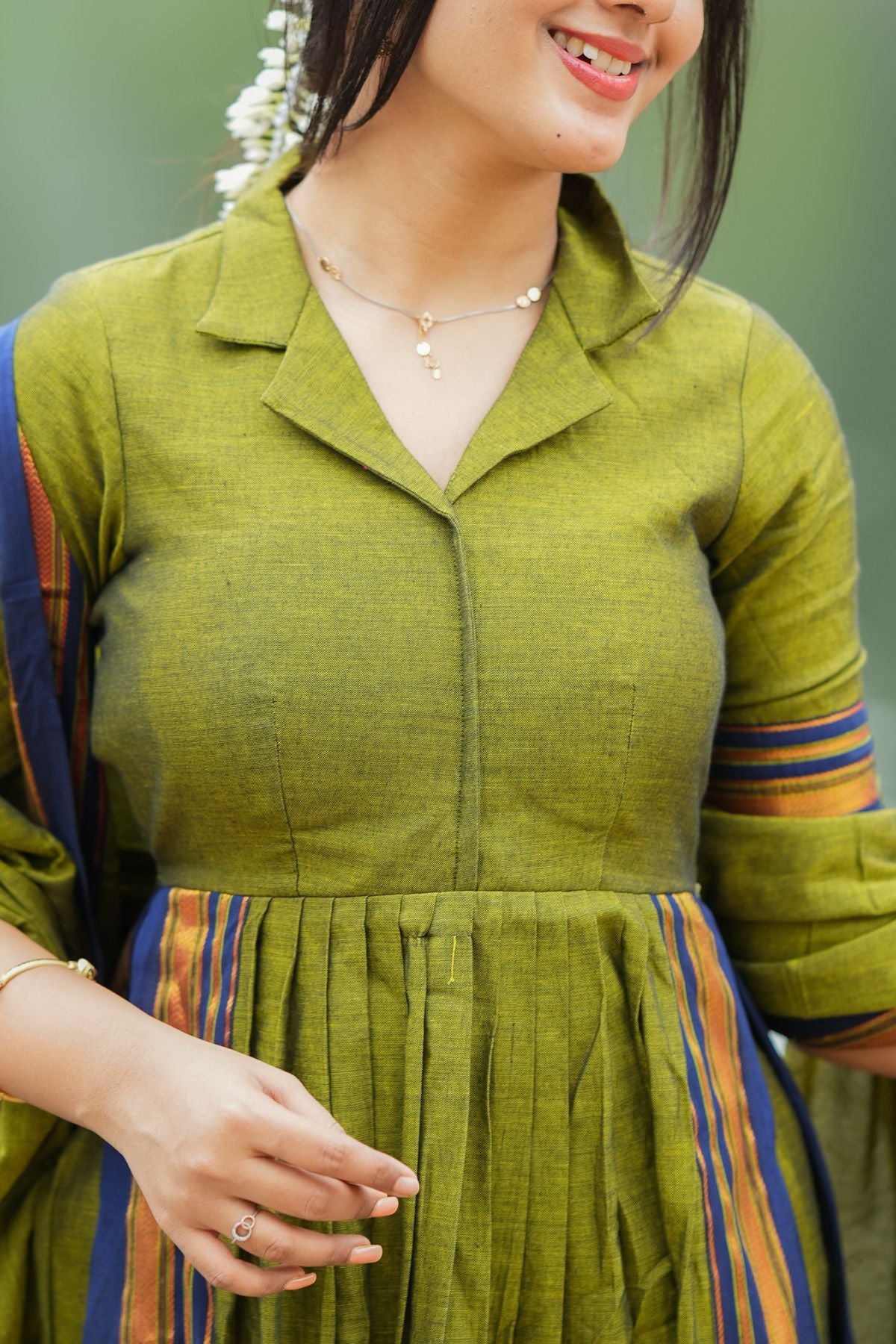 Detailed view of the Syahi Handloom Suit Set in olive green, highlighting the tailored fit and pleated design. A perfect traditional outfit at bullionknot.