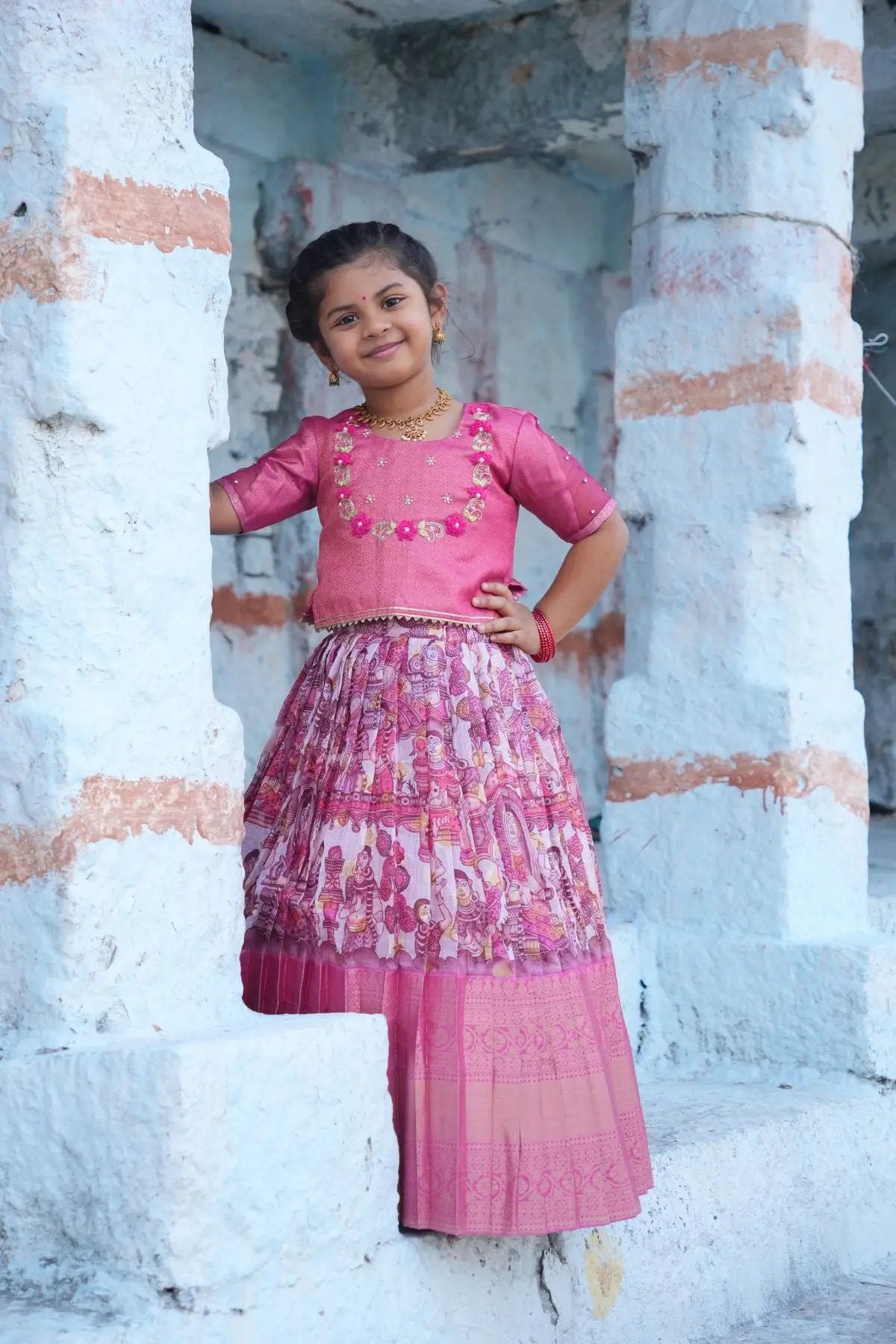 Traditional Baby Saanvi Lehenga Set in Pink, featuring a richly embroidered blouse and a pleated lehenga with intricate prints for festive wear.