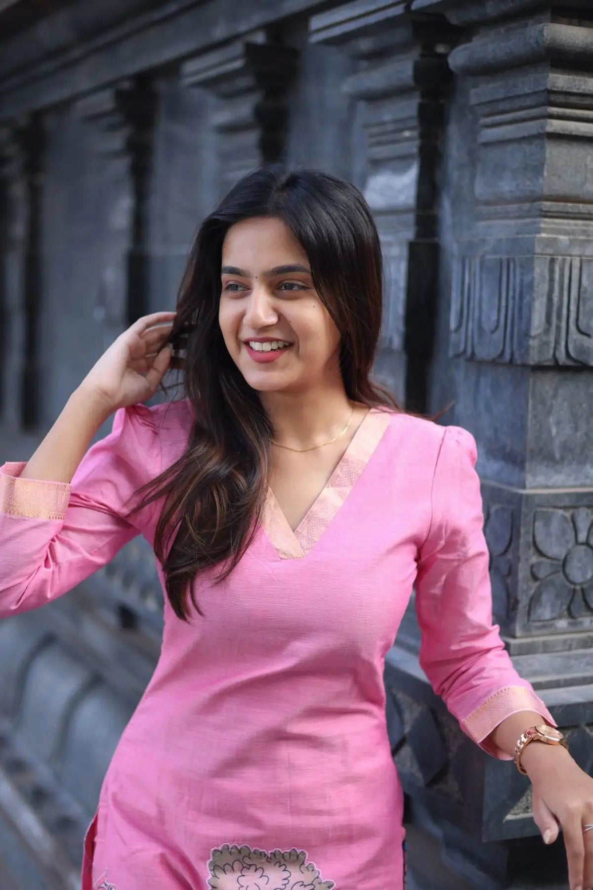 Smiling model in the Chhaavi Kurta Set in Pink, showcasing its elegant V-neck design and comfortable fabric for a graceful ethnic style.