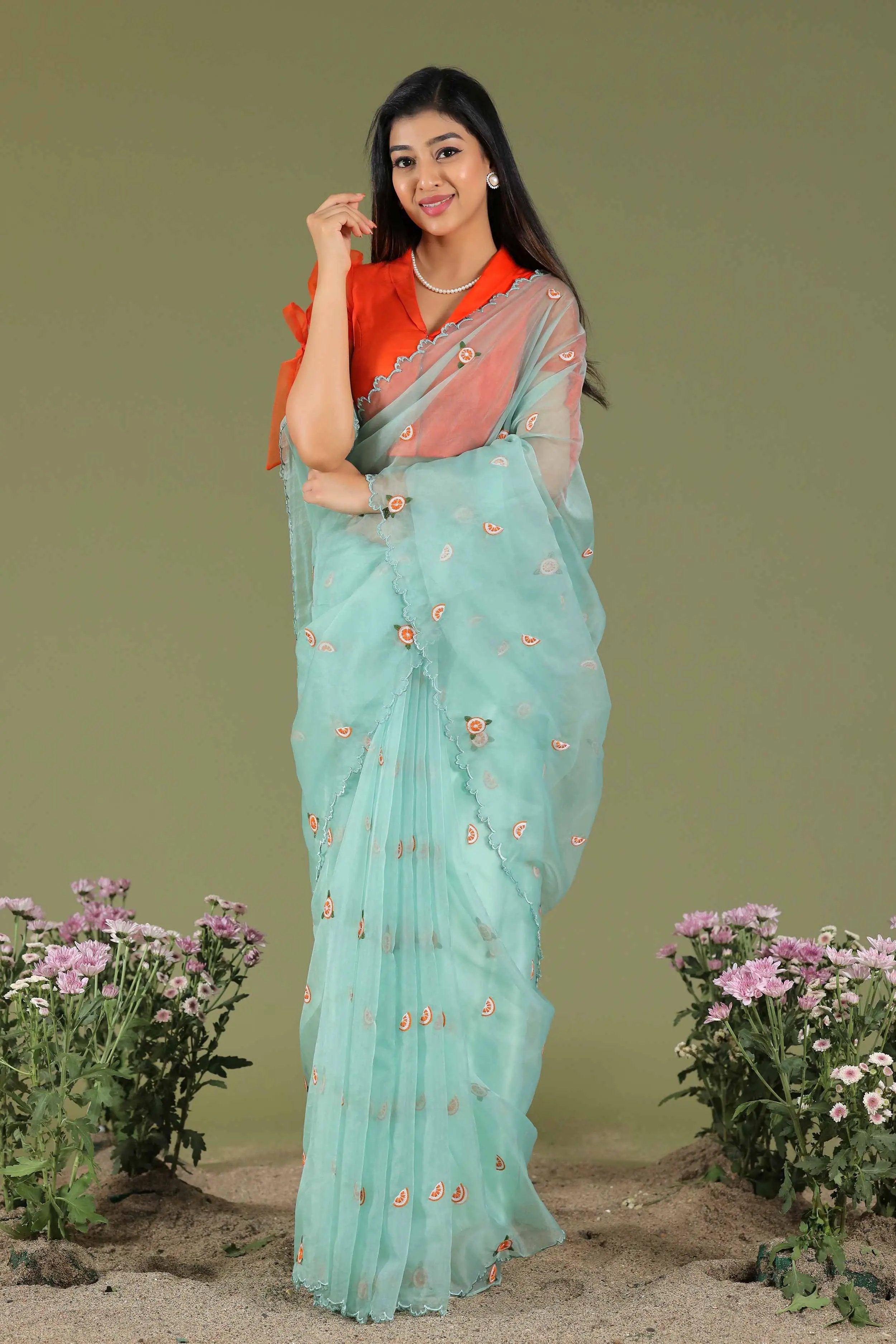 Model in turquoise organza saree and orange blouse