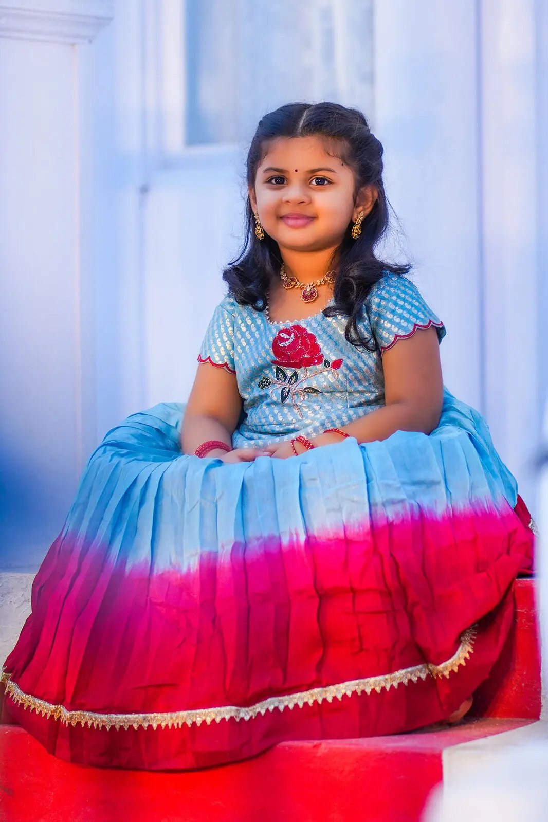 Toddler seated in Moonstone Blue Lehenga with red border