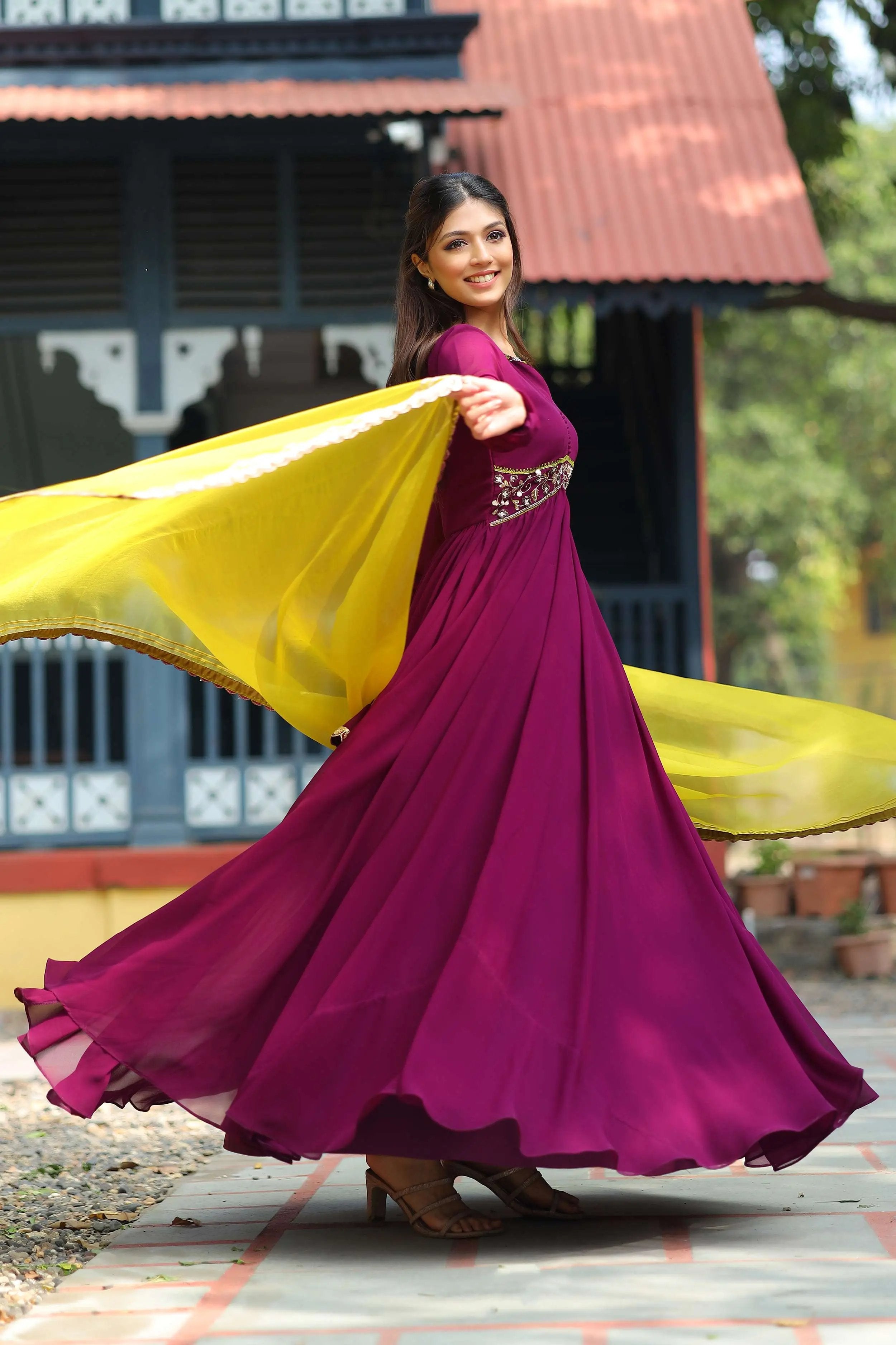 a woman in wine Anarkali Suit with yellow Dupatta