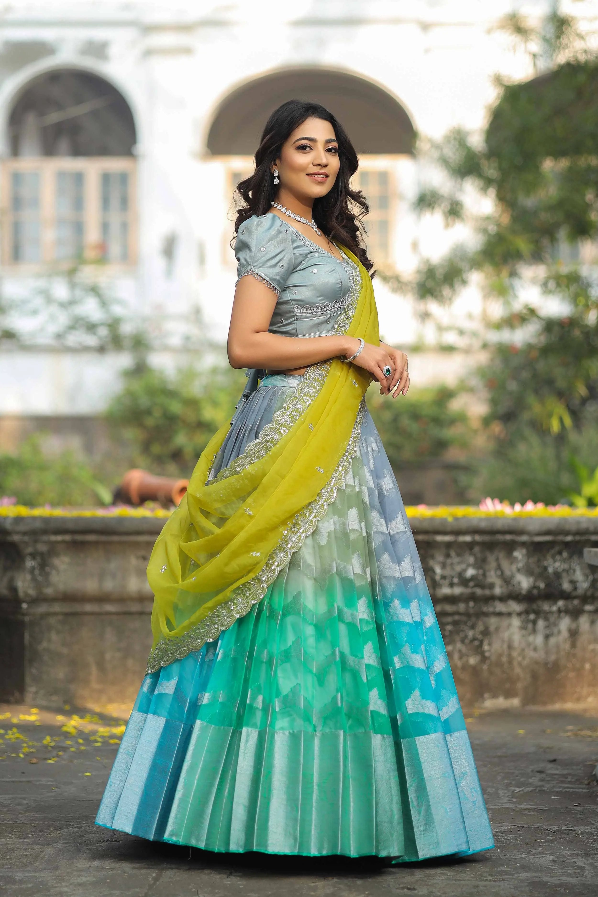 a woman in a green and blue lehenga dress