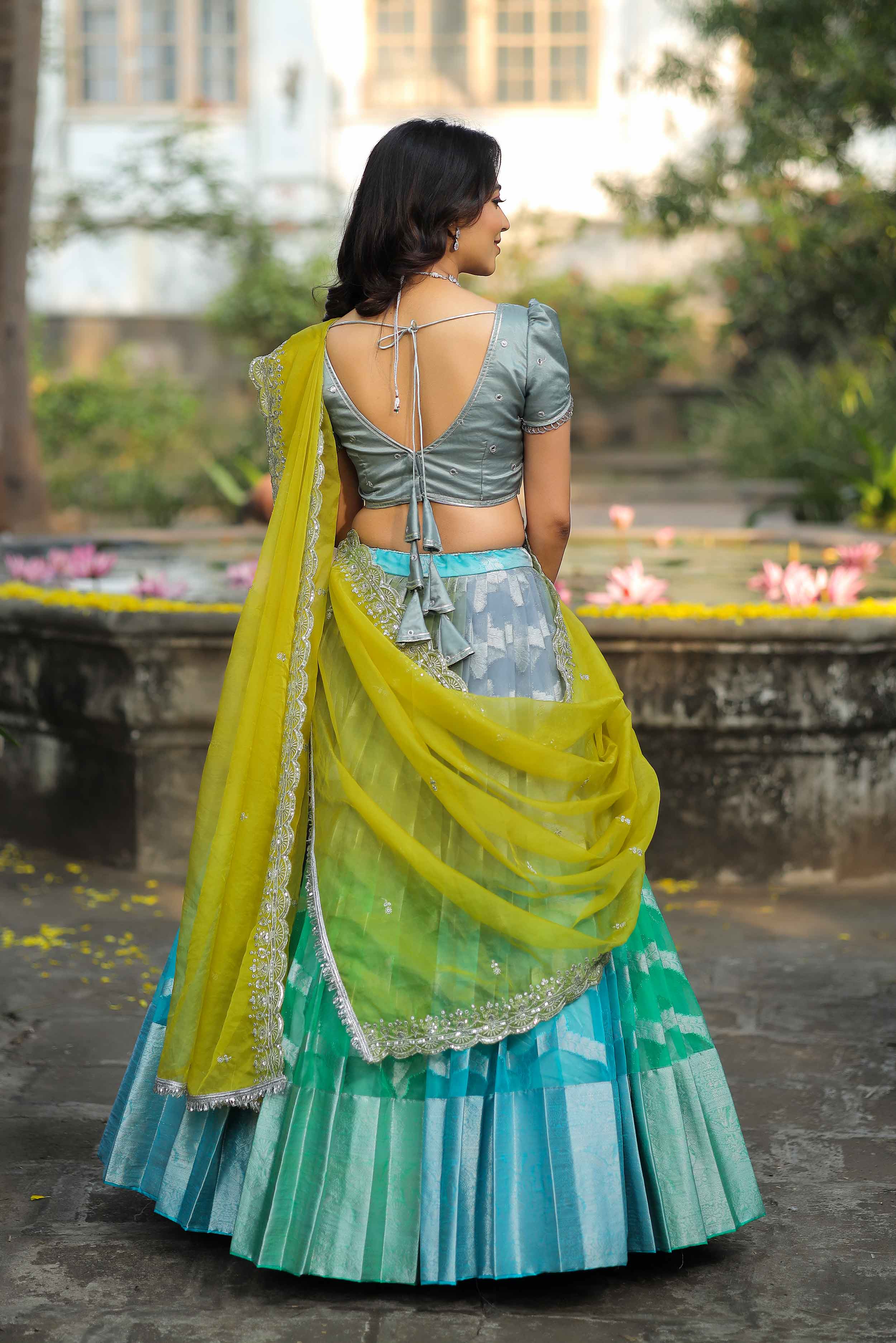 a woman in a green and blue half saree