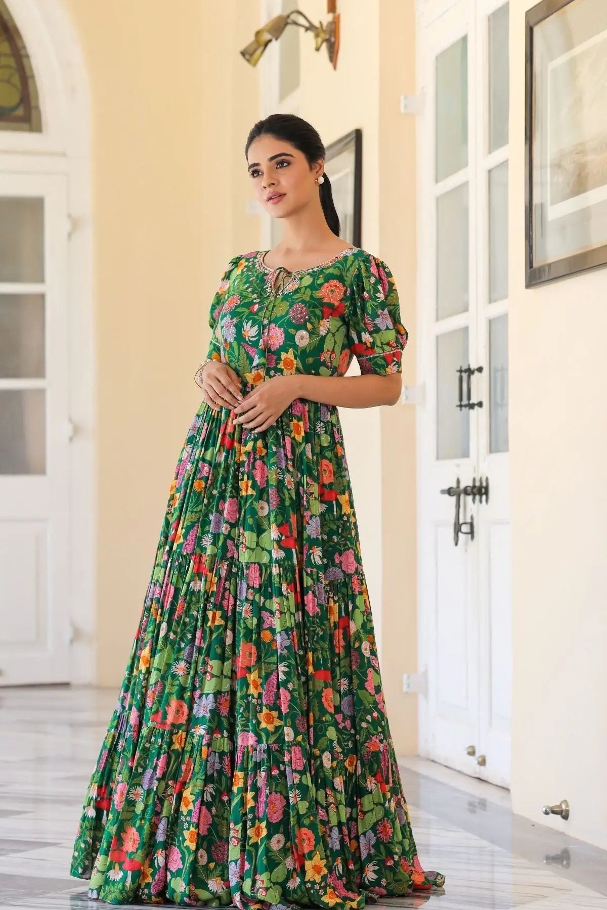 Side pose of Titli Maxi in Green with colorful floral patterns, puff sleeves, and a flattering pleated design for festive occasions.