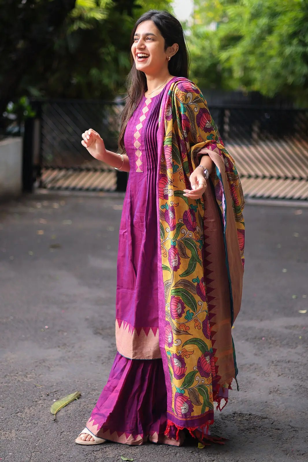 Model in purple sharara set, showcasing vibrant dupatta