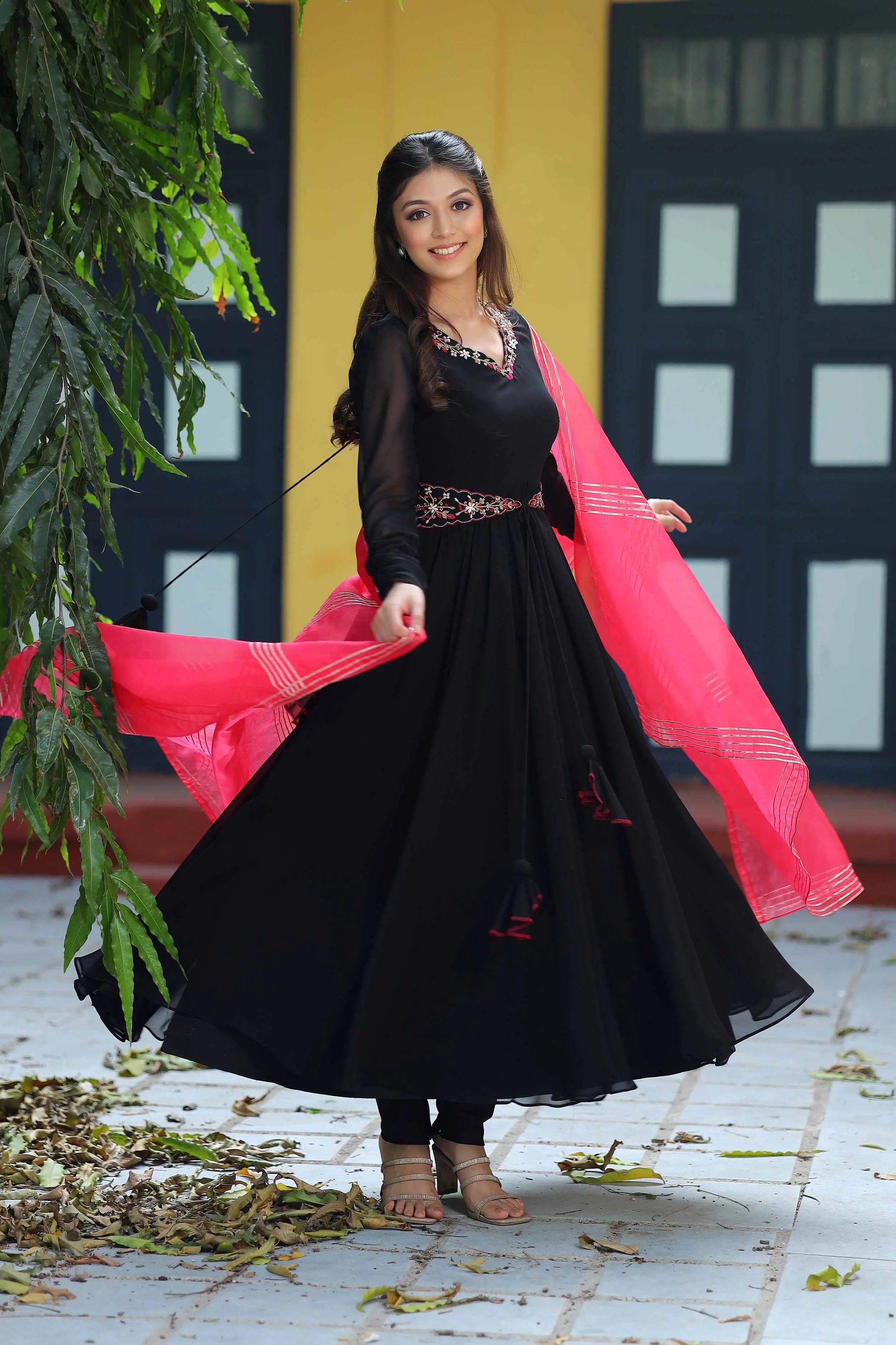 Stylish black Anarkali dress twirling with red dupatta