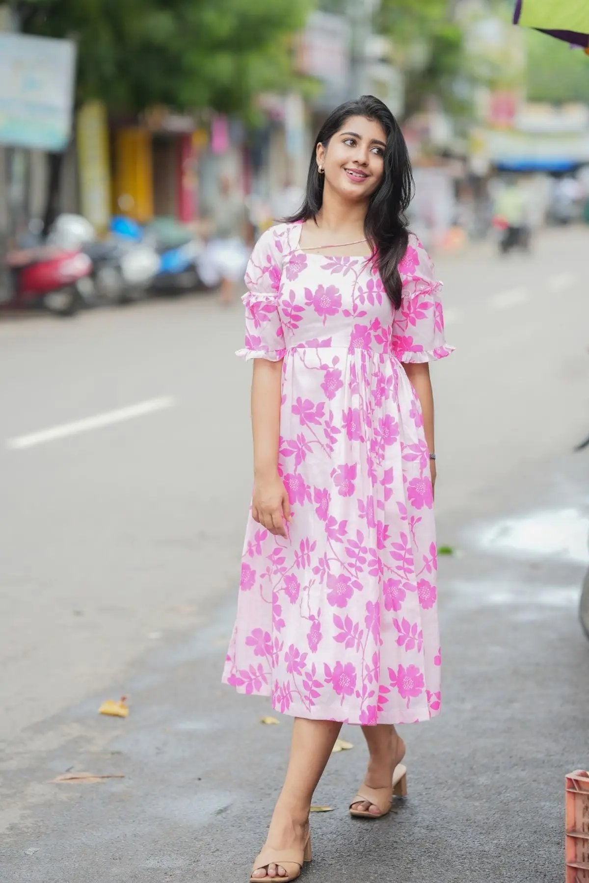 Polly Midi Dress in pink with floral print, styled with puffed sleeves and a flowy silhouette, ideal for casual outings.