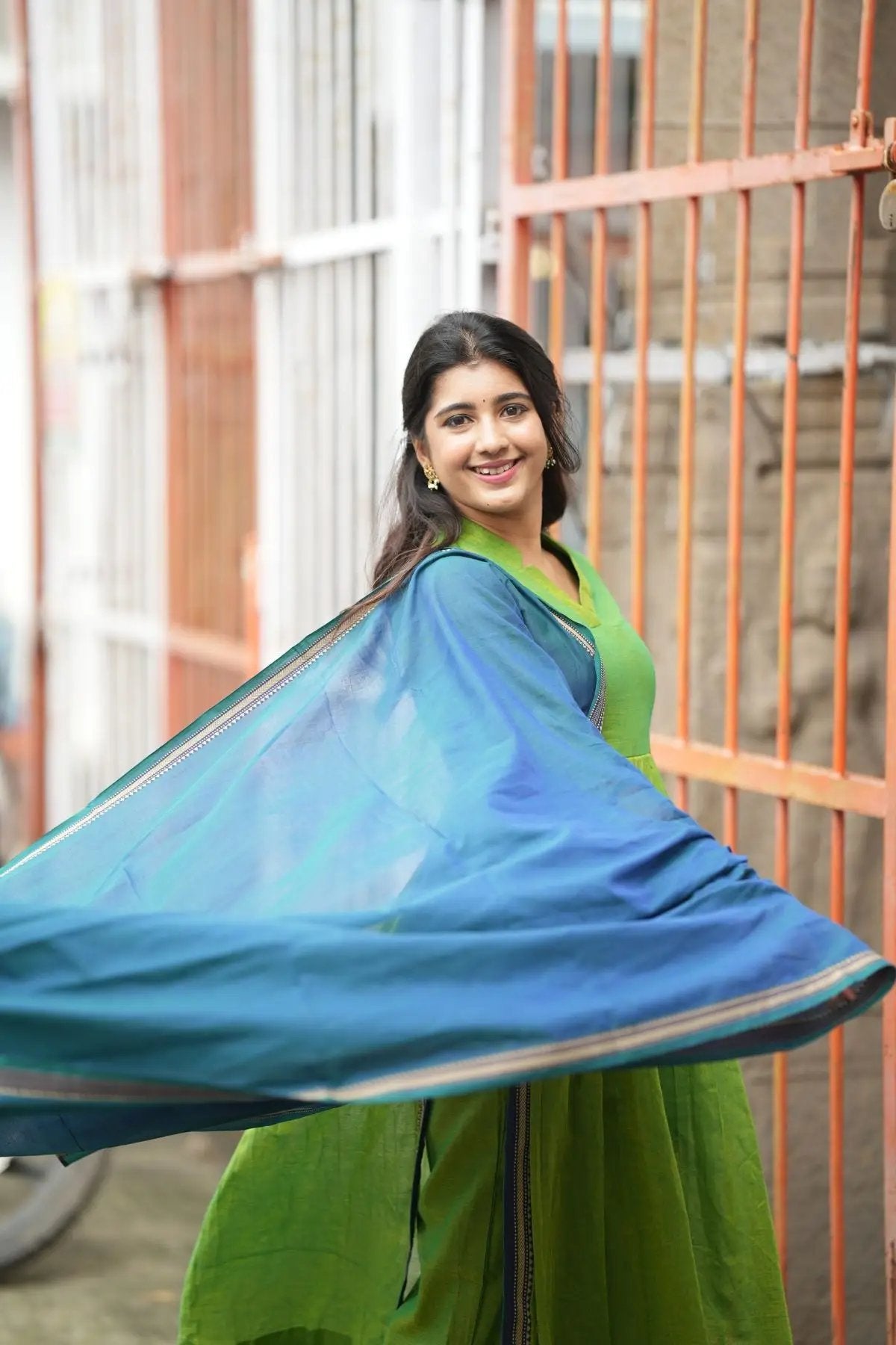 Punaam Kurta Set in green with a blue dupatta in motion, showcasing its lightweight and flowy design for traditional wear.