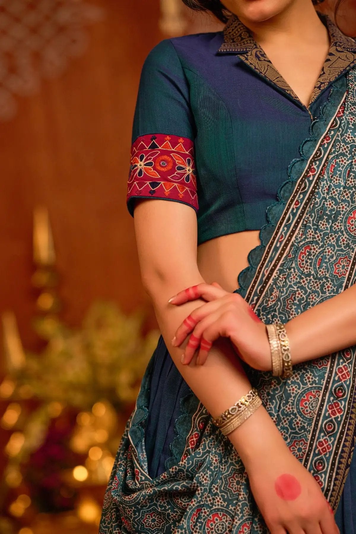 Close-up of Rudram Lehenga Set in peacock blue, highlighting embroidered blouse sleeves and detailed dupatta with traditional patterns.