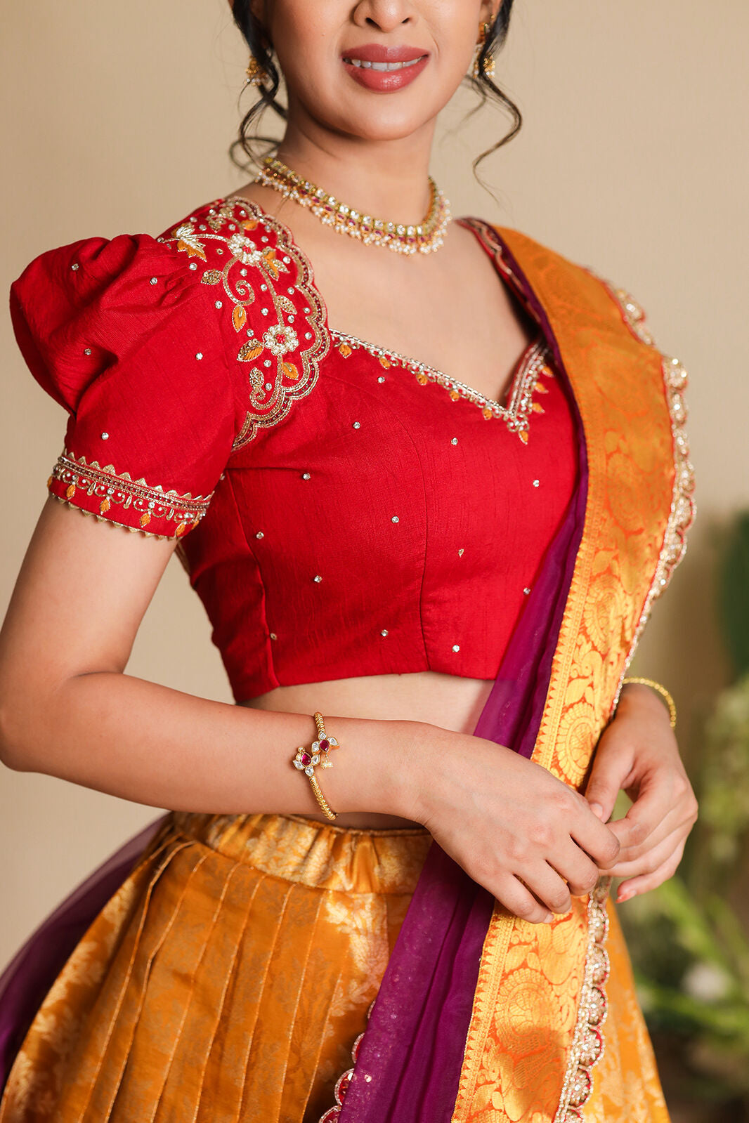 Close-up of Twisha red blouse with orange lehenga