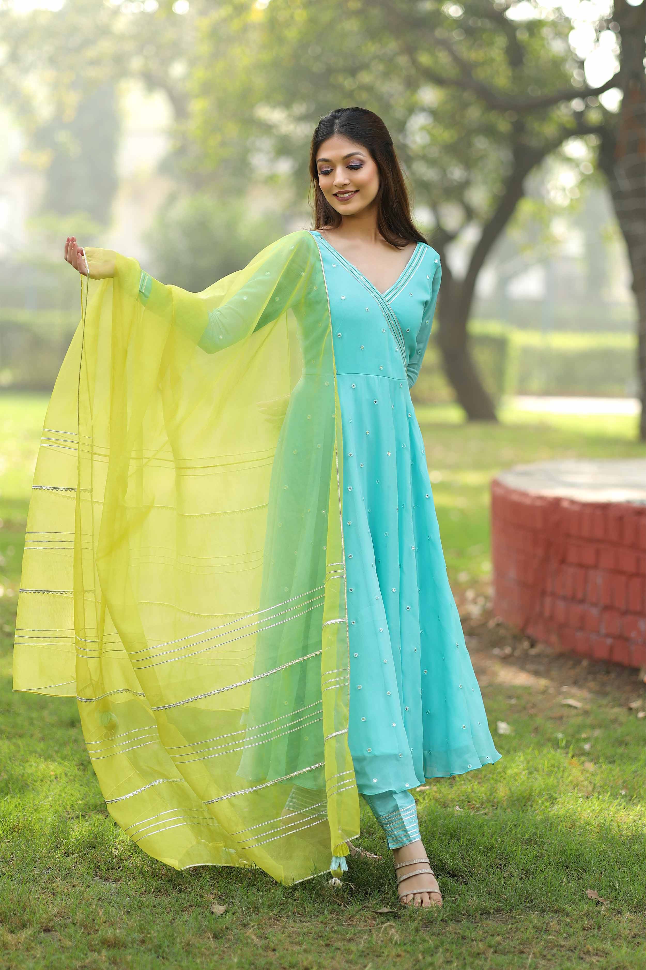 a woman in a blue dress holding a aqua and lime color dupatta, dress name is Victoria Mirror Anarkali Set