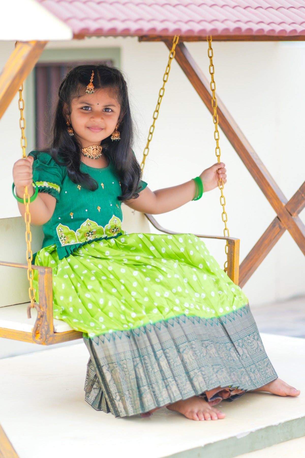 Girl in traditional light sea green lehenga on swing