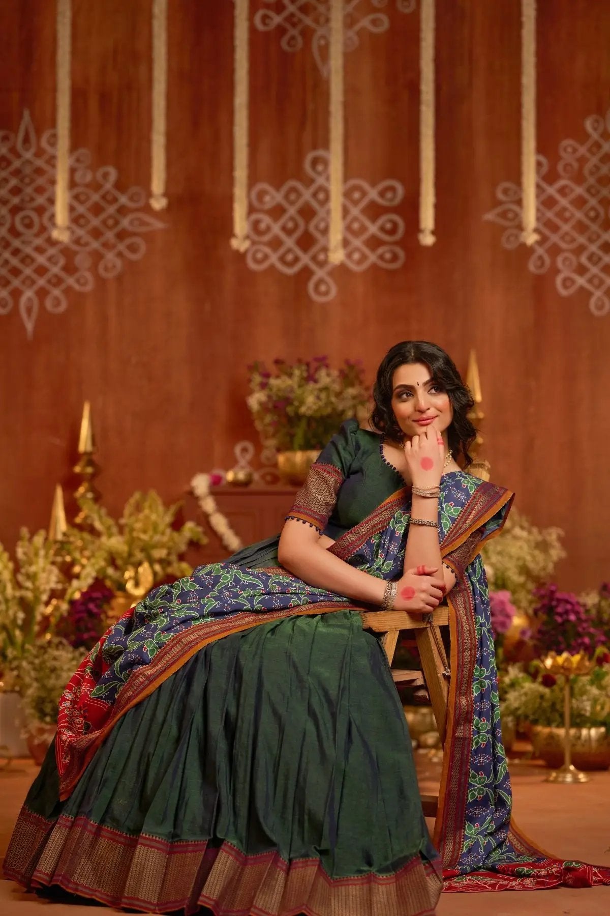 Model seated wearing Dhiwija Handloom Lehenga Set in peacock green, highlighting the elegant drape and traditional craftsmanship.