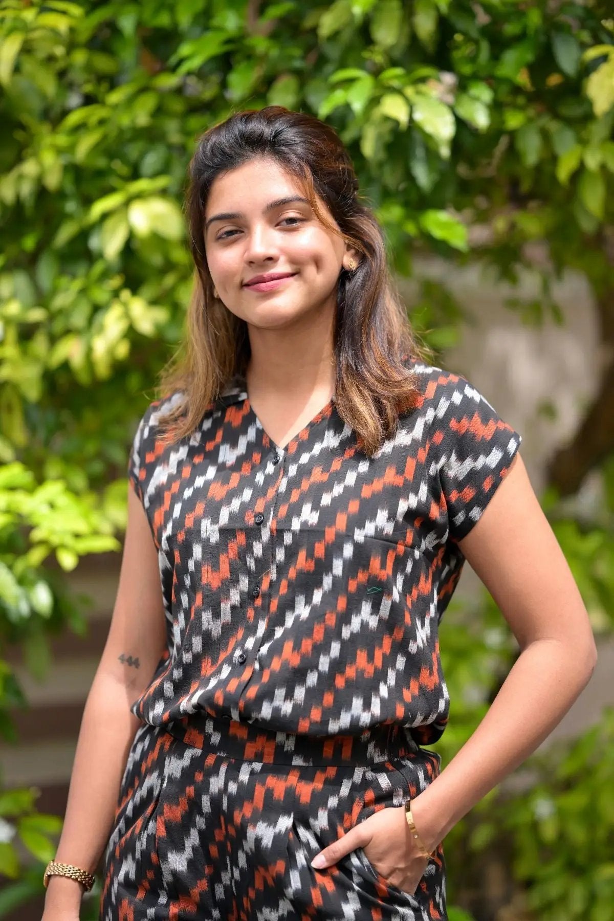 Smiling woman in patterned black and orange outfit